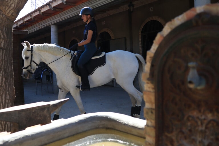 Chica montando a caballo con fuente